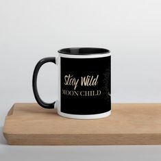 a black and white coffee mug with the words stay wild, moon child on it