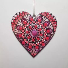 a heart shaped ornament hanging on a white wall