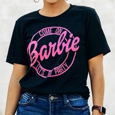 Brand New Women’s Barbie Shirt “Come On Barbie Lets Go Party” Size: Small Pit To Pit: 20” Color: Black & Pink Pink Letter Print Party Top, Pink Letter Print Top For Party, Casual Pink Party T-shirt, Pink Casual T-shirt For Party, Casual Pink T-shirt For Party, Fun Black Party Tops, Black Fun T-shirt For Casual Party, Fun Black T-shirt For Party, Fun Black Party T-shirt