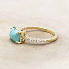 a gold ring with a turquoise stone and diamonds