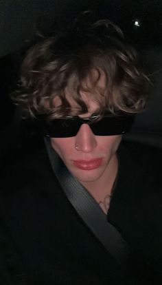 a woman with sunglasses on her face and hair in the back seat of a car