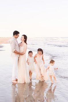 a family standing on the beach in front of the ocean