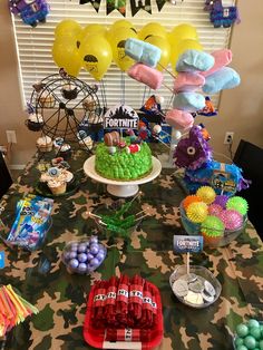 a table topped with lots of cake and balloons