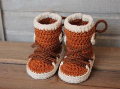 a pair of brown and white crocheted baby boots