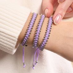 Finish: Silver Cord: Lilac Adjustable Nylon Size: One Size Fits All Base: Stainless Steel The Friendship DOT Bracelets are hand-crafted from bars gilded in silver, black gunmetal, or rainbow unicorn silver and are hand-strung on an adjustable nylon cord. The Friendship DOT Bracelets come with an engraved logo bar in a matching finish. With their adjustable colored nylon cord, the Friendship DOT Bracelets are one-size-fits-all. Metal Braided Bracelets For Friendship, Silver Braided Bracelets With Adjustable Cord, Adjustable Metal Braided Bracelets, Adjustable Silver Nylon Cord Friendship Bracelets, Silver Friendship Bracelet With Sliding Knot, Silver Beaded Bracelets With Sliding Knot, Adjustable Purple Metal Beaded Bracelets, Mermaid Glass, The Friendship