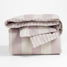 the pink and white striped bedding is folded up on top of it's pillow