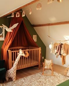 a baby's room with a giraffe in the crib and clothes hanging up