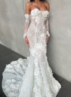 a woman in a white wedding dress standing next to a wall