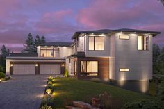 a two story house at dusk with lights on the windows and landscaping in front of it