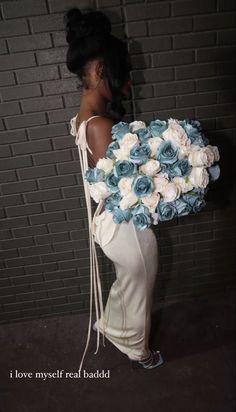 a woman holding a bouquet of flowers in front of a brick wall with the words i love my self