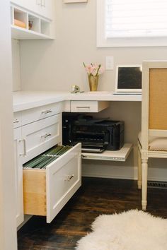 a white desk and chair in a small room