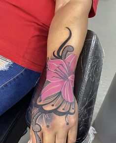 a woman's foot with a flower tattoo on her left arm and the other hand