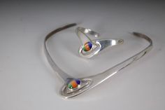 vintage minimalist collar necklace + matching cuff bracelet set.  crafted from sterling silver.  Space age, minimalist design with tri-colored cabochon gemstones. circa 1960s/1970s.  Marked 925, Mexico.   Measures: 5" across, 5 1/2" length. Cuff:  2 1/2" across, 1 1/2" wide. very good vintage, preowned condition.  minimal superficial surface wear, presents well + ready to wear as is. Please ask questions before purchasing, all sales are final. Modern Multicolor Polished Jewelry, Silver Modernist Jewelry With Polished Finish, Modernist Silver Jewelry, Mid-century Adjustable Silver Jewelry, Mid-century Silver Necklace Gift, Mid-century Collectible Silver Jewelry, 1970s Jewelry, Modernist Sterling Silver Cabochon Jewelry, Collar And Cuff