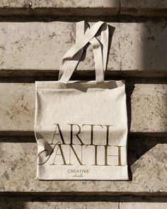 an artful bag hanging on the side of a building with words written on it