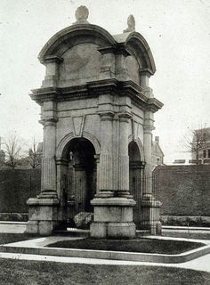 an old black and white photo of a small building in the middle of a park