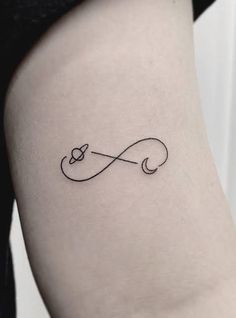 a small tattoo with an infinite symbol on the side of the thigh, which is black and white