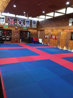 an indoor gym with blue and red mats