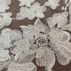 an embroidered fabric with white flowers on it