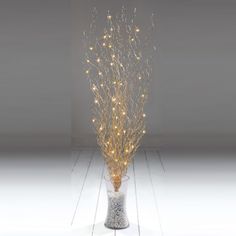 a vase filled with lights on top of a white floor