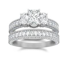 three stone engagement ring set with diamonds on the sides and two bands around the band