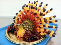 a platter with grapes, pineapples and other fruit arranged in the shape of a hedgehog