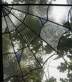 a close up of a stained glass window with trees in the background