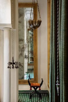 a room with a mirror, chandelier and black and white checkered floor