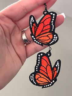 a pair of orange and black butterfly earrings