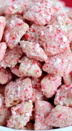 a white bowl filled with pink and red sprinkled dog treats on top of a table