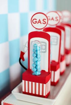 there are three red and white candy dispensers on the counter with blue candies in them