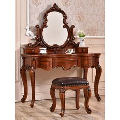 an ornate wooden vanity with mirror and stool