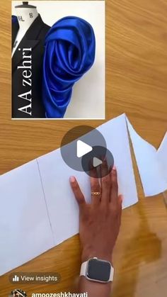 someone is cutting out paper with scissors on a wooden table next to an origami piece