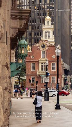 a woman is walking down the sidewalk in front of a building