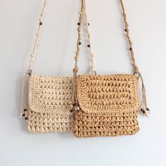 two crocheted purses hanging on a wall