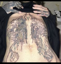 a woman with tattoos on her stomach and chest