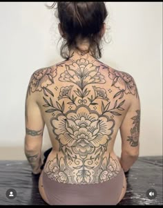 the back of a woman's body with tattoos on it