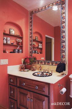 a bathroom with pink walls and wooden cabinets