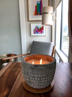 a lit candle sitting on top of a wooden table