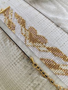 a close up of a gold chain on a wooden surface