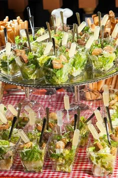 a table topped with lots of salads and desserts on top of glass plates