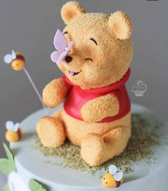 a winnie the pooh cake is decorated with honeybees