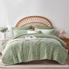 a bed with a green comforter and pillows