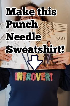 a woman holding up a poster with the words make this punch needle sweatshirt