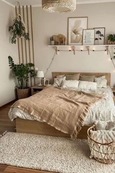 a bedroom with white walls and wooden flooring is decorated in neutral tones, including beige bedding