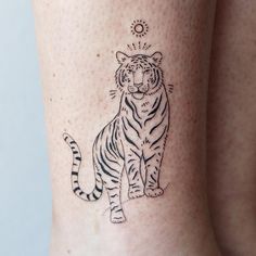 a tiger tattoo on the leg of a woman