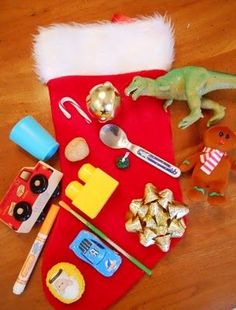 a christmas stocking filled with toys on top of a wooden table next to other items