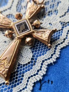 Antique cross pendant, dating from the nineteenth century, rose gold plated, engraved and enameled. There is a religious motif on one side and a floral motif on the other. The cross shows several signs of wear. There are a few chips on the enameled part with a flower. The plating is gone in places and there are small marks and indentations. The cross is very light. Dimensions: about 5.9 cm x 3.8 cm. Possible variations of color due to the light. Antique Ceremonial Cross Jewelry, Antique Cross Jewelry For Ceremonial Occasions, Antique Cross Necklaces For Collectibles, Antique Crucifix Collectible Jewelry, Antique Collectible Cross Jewelry, Antique Bronze Crucifix Jewelry, Antique Collectible Crucifix Jewelry, Victorian Cross Necklace For Formal Occasion, Antique Engraved Cross Necklace