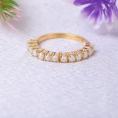 a close up of a ring on a table with flowers and purple flowers in the background