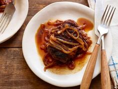 a white plate topped with meat covered in sauce