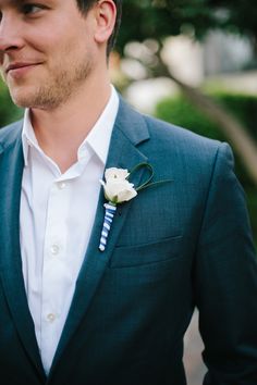 a man in a suit with a boutonniere and flower on his lapel